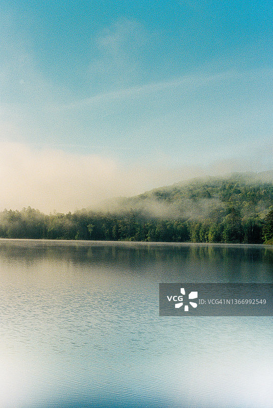 在阿迪朗达克山脉，晨雾笼罩着树木和湖泊图片素材