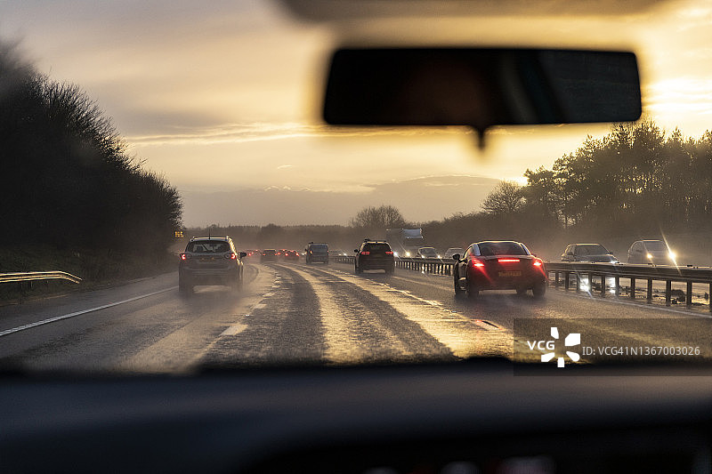 从汽车上看到日落时高速公路上的交通图片素材