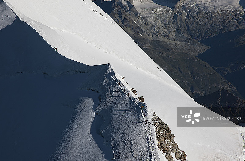 攀登者在积雪的山脊上图片素材