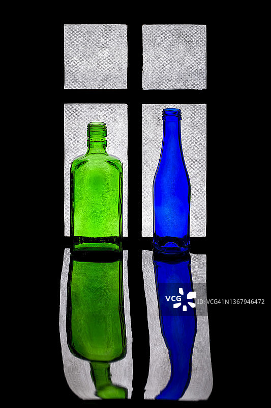 绿色和蓝色的瓶子贴在窗户上的静物图片素材