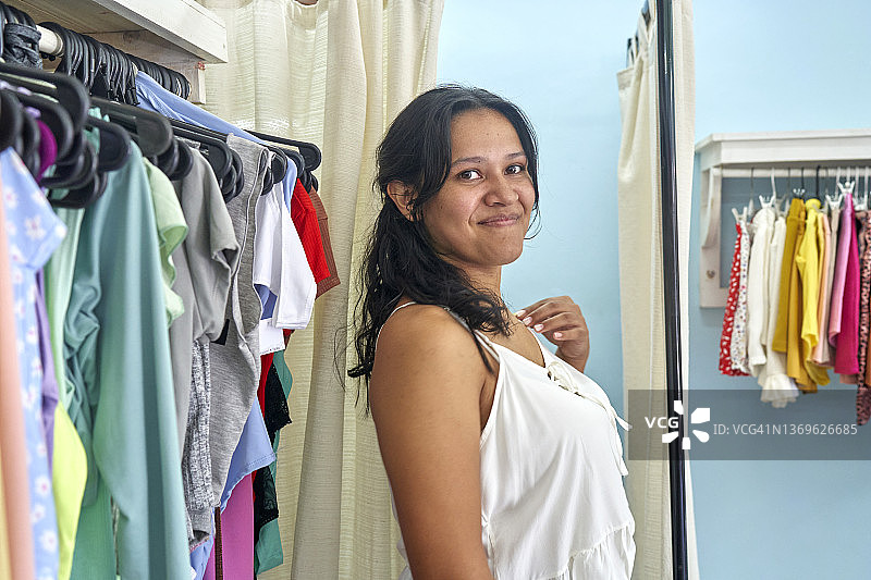 年轻的拉丁妇女在服装店购物图片素材