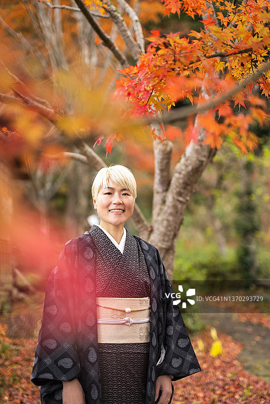 日本妇女和服站在彩色的秋叶下图片素材