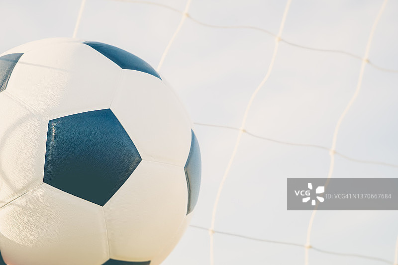 在蓝色的天空自然背景下的球网皮革足球图片素材