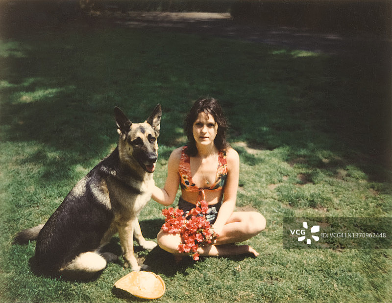 70年代的女人与德国牧羊犬，复古嬉皮女人与酷的态度图片素材