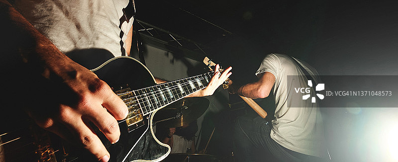 硬摇滚吉他手在舞台灯光下的现场表演中演奏吉他图片素材