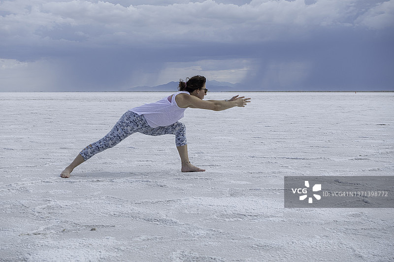 一名女子在犹他州的博纳维尔盐滩练习瑜伽图片素材