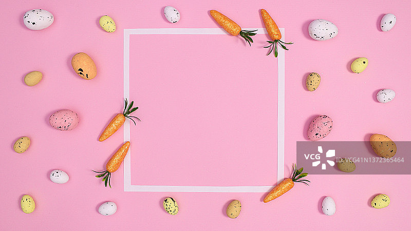 粉彩的背景与白色复制空间框架包围复活节彩蛋和胡萝卜。春天节日装饰品。平把概念图片素材