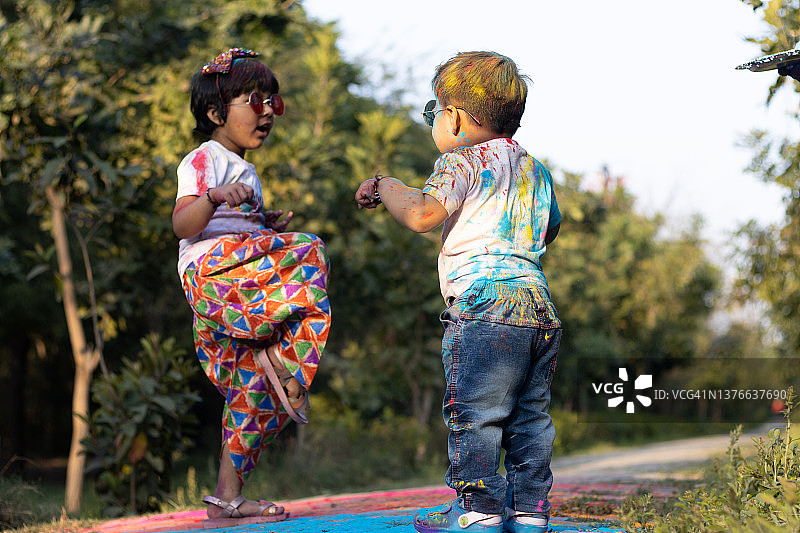 快乐的亚洲印度孩子男孩和女孩享受节日的颜色与胡里彩粉称为古拉尔或范围图片素材