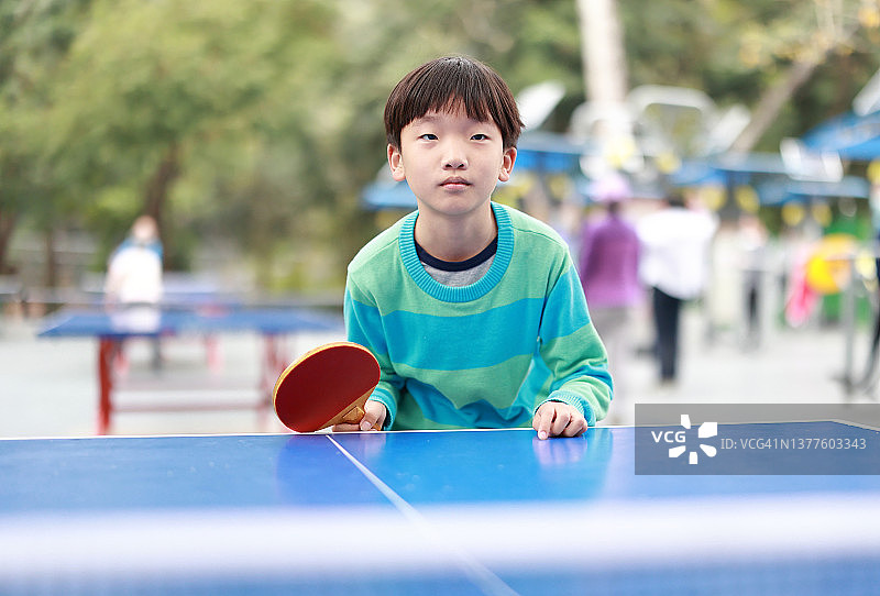 男孩在花园里打乒乓球图片素材
