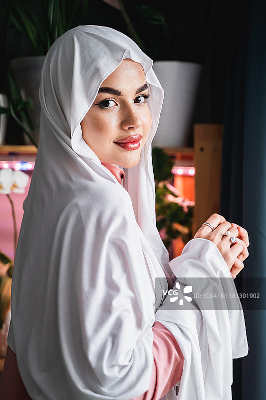 平静的梦想周到的微笑吸引自信的穆斯林妇女在正式优雅的白色头巾头巾。图片素材