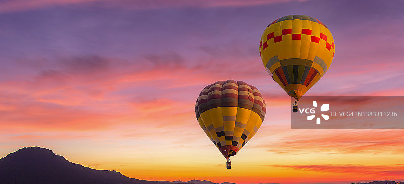 五颜六色的热气球映衬着五彩缤纷的日出天空。图片素材