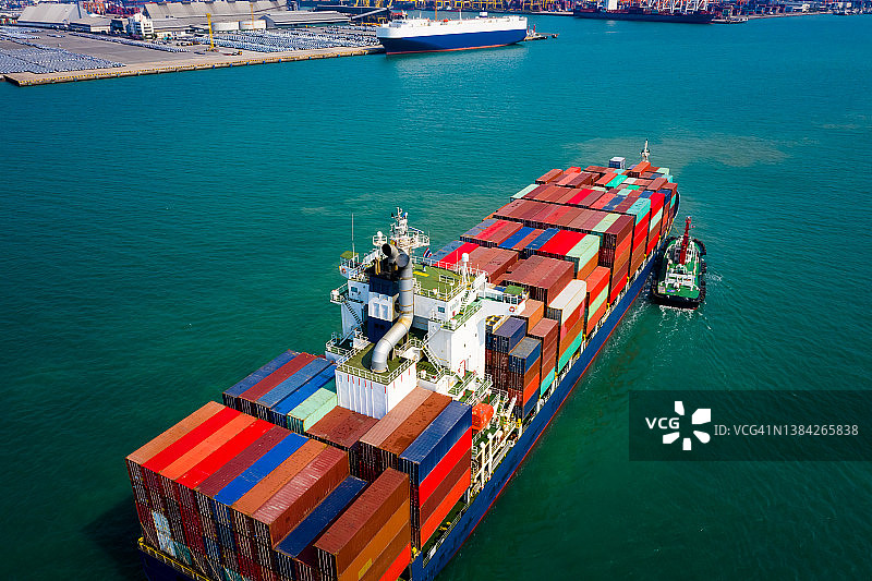 集装箱船在碧海中航行，拖船拖船到海港图片素材