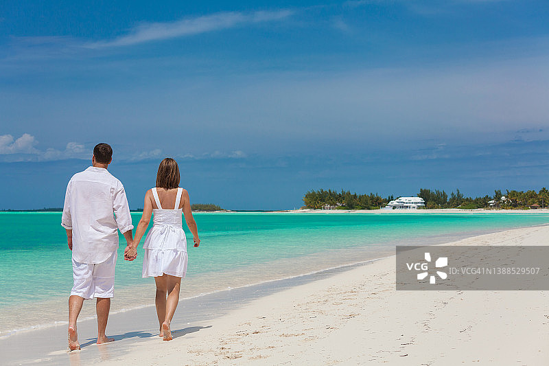 一对相爱的白人夫妇在海滩度假胜地散步图片素材