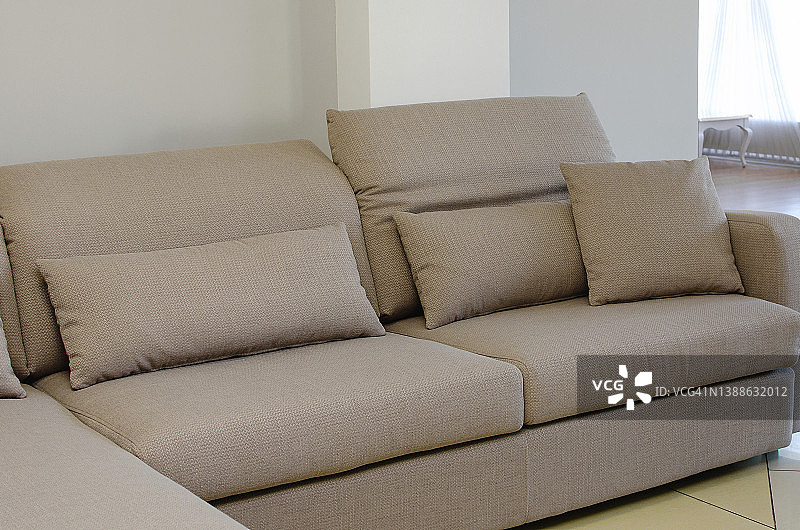 现代米色沙发与软装饰枕头。简约的室内设计。图片素材