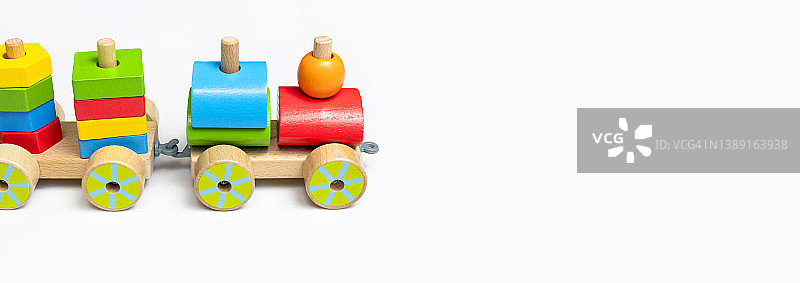 白色背景上的彩色方块木制火车。用天然木材制成的五颜六色的儿童玩具。环保玩具，游戏，不含塑料。婴幼儿玩具。平卧侧视图图片素材