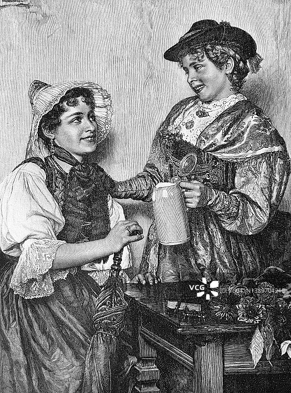 两个喝啤酒的巴伐利亚年轻女人图片素材