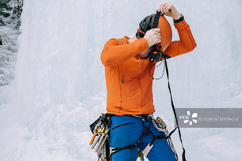 一名冰上登山者在结冰的瀑布底部放置雪崩收发信标图片素材