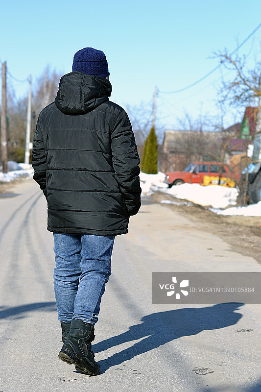 一个男孩站在乡村的路上。图片素材