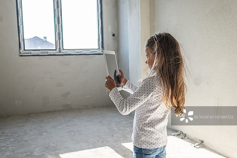 快乐的小女孩在施工时使用数字平板电脑图片素材