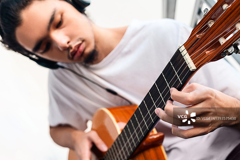 年轻的亚洲人演奏原声吉他图片素材