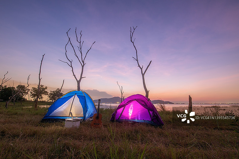 在美丽的日落照片期间，在水库旁搭起帐篷和营地图片素材