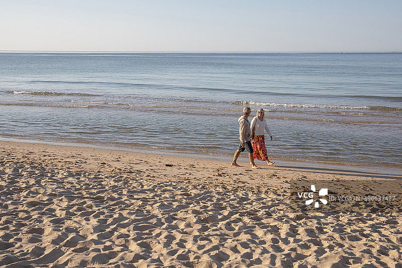 成熟的情侣赤脚走在沙滩上图片素材