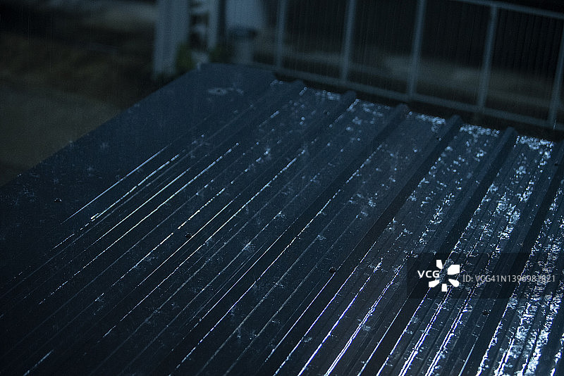 大雨在晚上的时候落在屋顶上图片素材