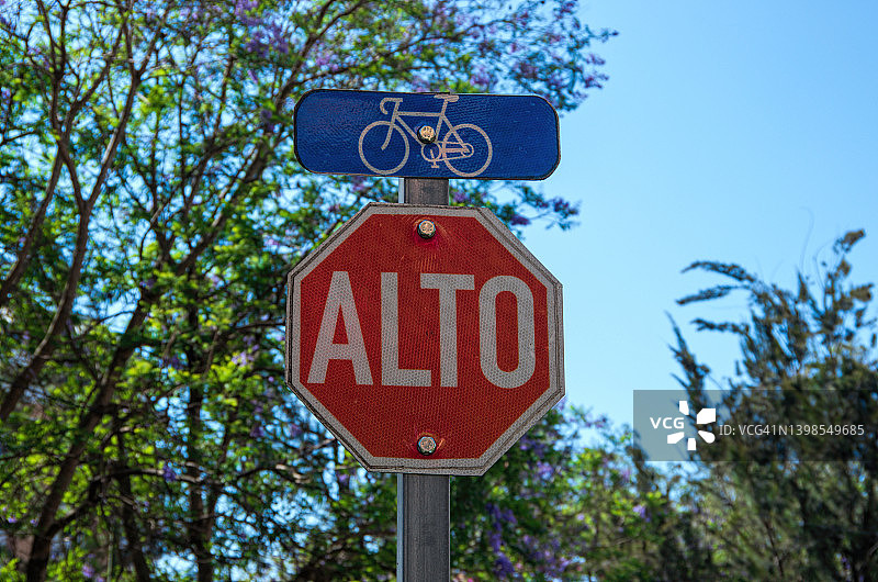 城市中的自行车道和西班牙语的“Alto”(停止)标志图片素材
