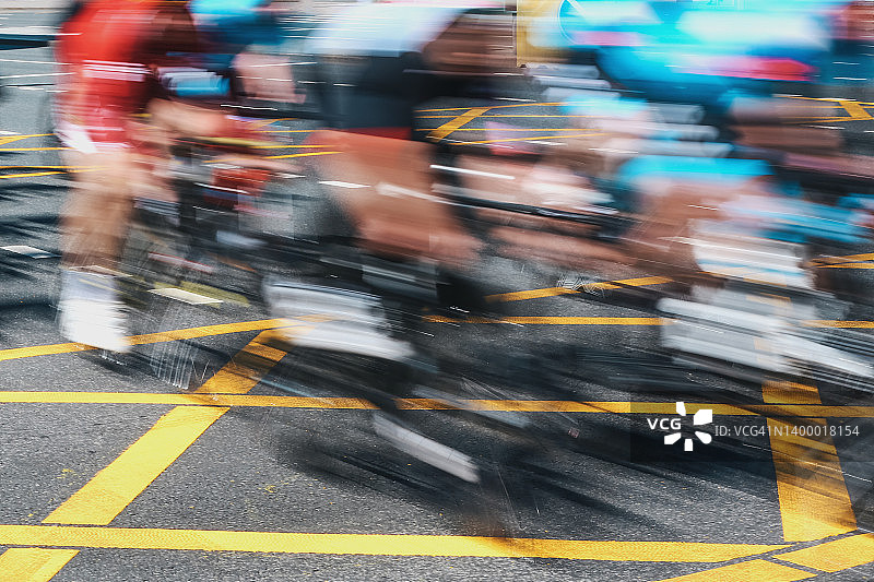 散焦彩色自行车背景。不知名的业余爱好者在街上快速骑行图片素材