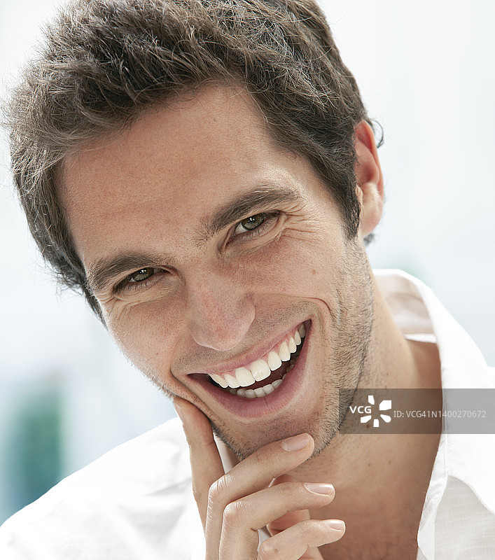 阳光的肖像，一个年轻英俊的男子微笑着看着镜头图片素材