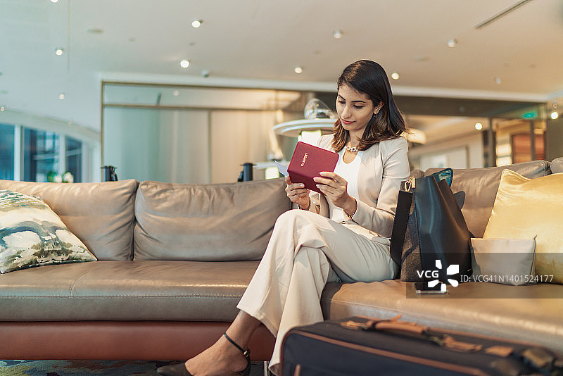 商务旅行——乘坐头等舱的印度女商人正在检查她的登机牌图片素材