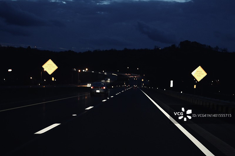 照明的公路线路和标志在黑暗的道路图片素材