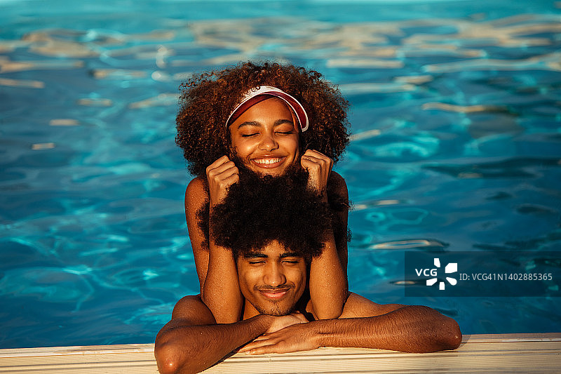 年轻漂亮的黑人男女在游泳池游泳的肖像图片素材