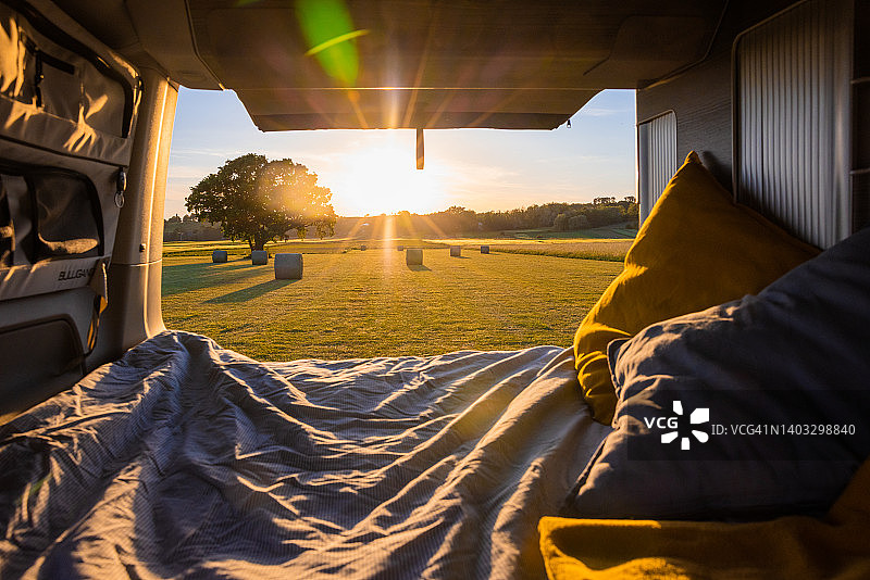 日落时的农田和干草捆，从一辆面包车的后门看图片素材