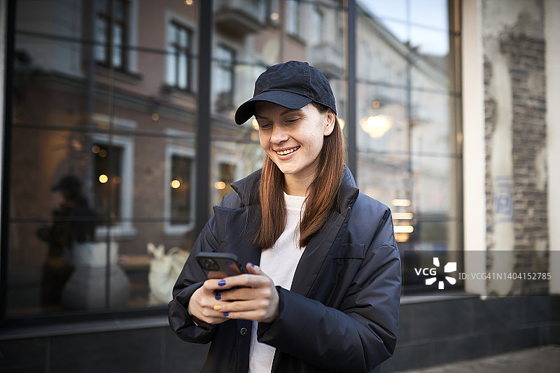 城市里微笑着使用手机的女人图片素材