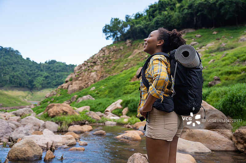开朗的年轻黑人女性喜欢在夏天的周末去山上徒步旅行图片素材