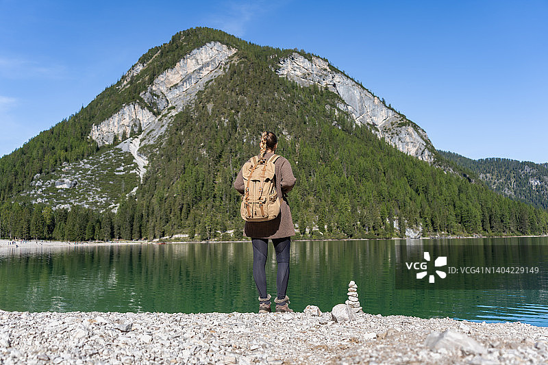 背景的女人徒步旅行者与背包享受在山湖图片素材