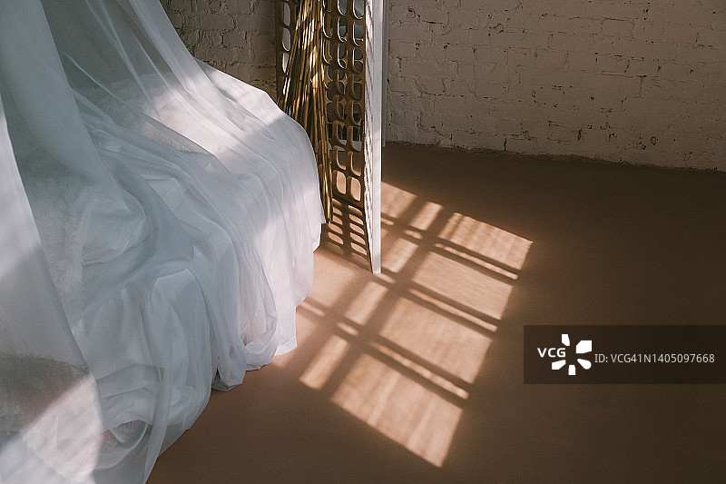 窗外的光线照在一张有窗帘的白色床上图片素材