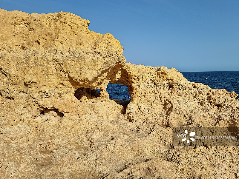 在葡萄牙阿尔加维卡沃埃罗的Algar Seco石灰岩悬崖上的天然洞图片素材