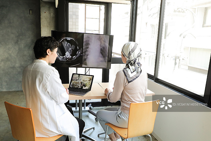 亚洲癌症患者与医生讨论治疗方案图片素材