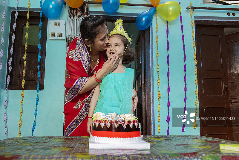 快乐的孩子和她的妈妈的肖像和生日蛋糕图片素材