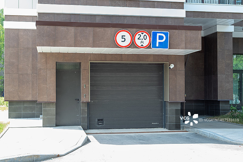 封闭的地下停车场入口设有视频监控和路牌。图片素材