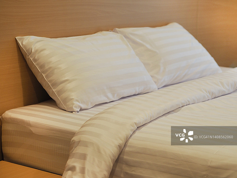 床上有两个枕头，白色的床单图片素材