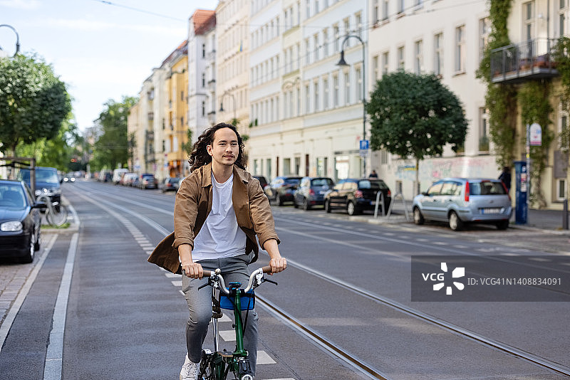 一个年轻人在城市街道上骑自行车图片素材