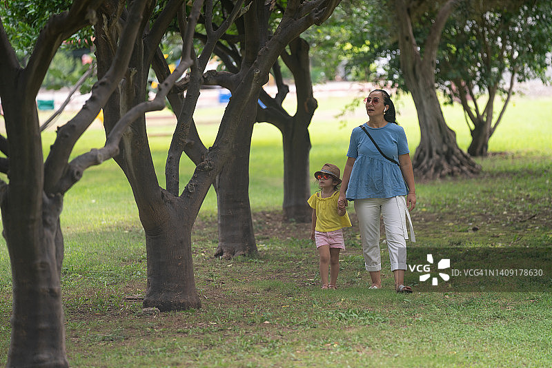 母亲和小女儿在公园散步的照片图片素材
