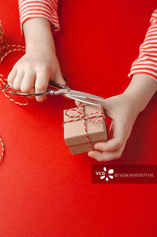 儿童手中的礼物工艺盒，圣诞礼物包装。一个快乐的节日的概念。图片素材