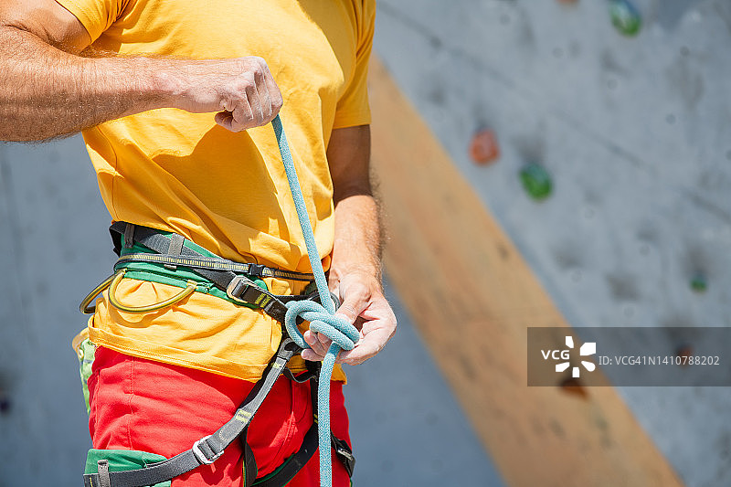 一名男子准备爬上一条攀登路线。攀岩之保险及安全。图片素材
