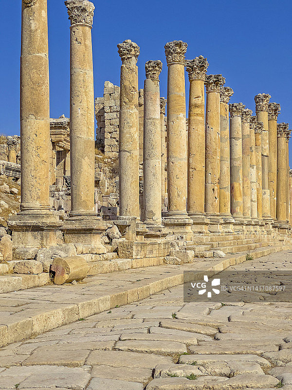 经典的科林斯式圆柱排列在杰拉什罗马遗址中心的石砌街道或车行道上。图片素材