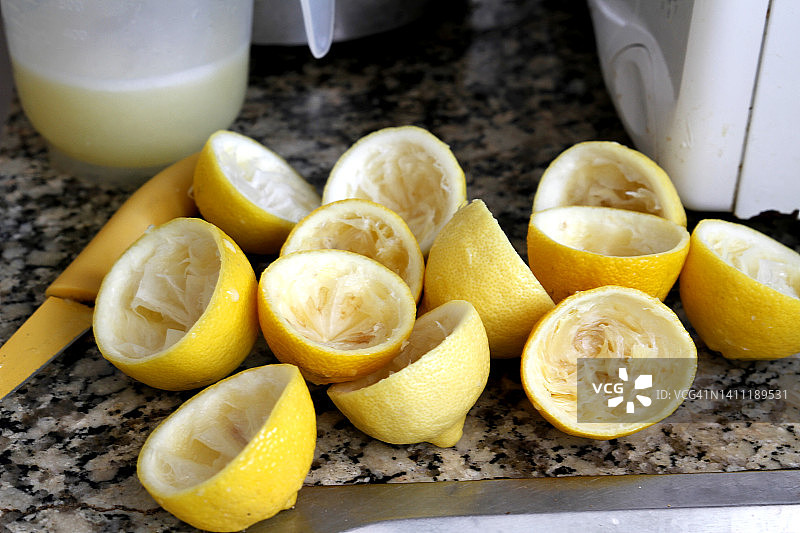 一壶柠檬水和挤柠檬放在厨房的桌子上图片素材
