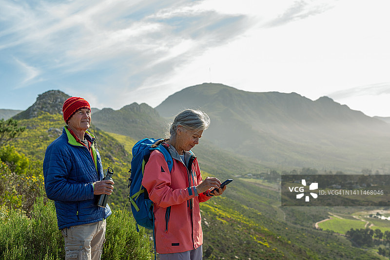 一位老妇人在爬山时用手机导航图片素材